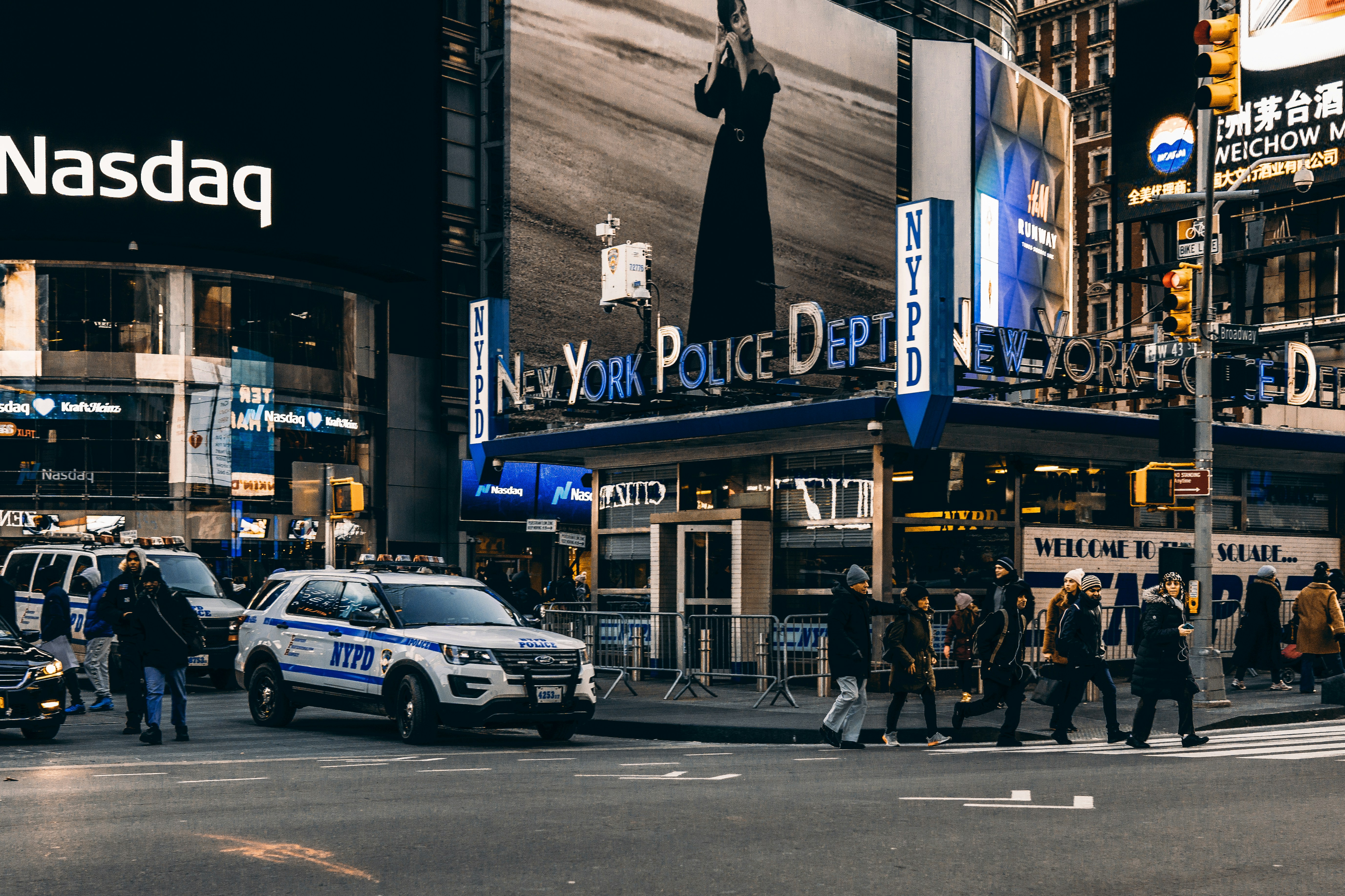 NYPD Times Square precinct at night, showing a patrol car and the New York Police Dept signage